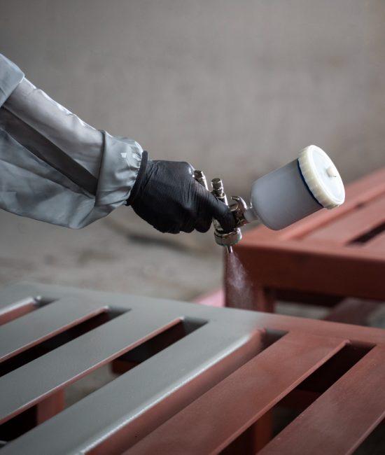 worker-spraying-powder-paint-from-gun-side-view